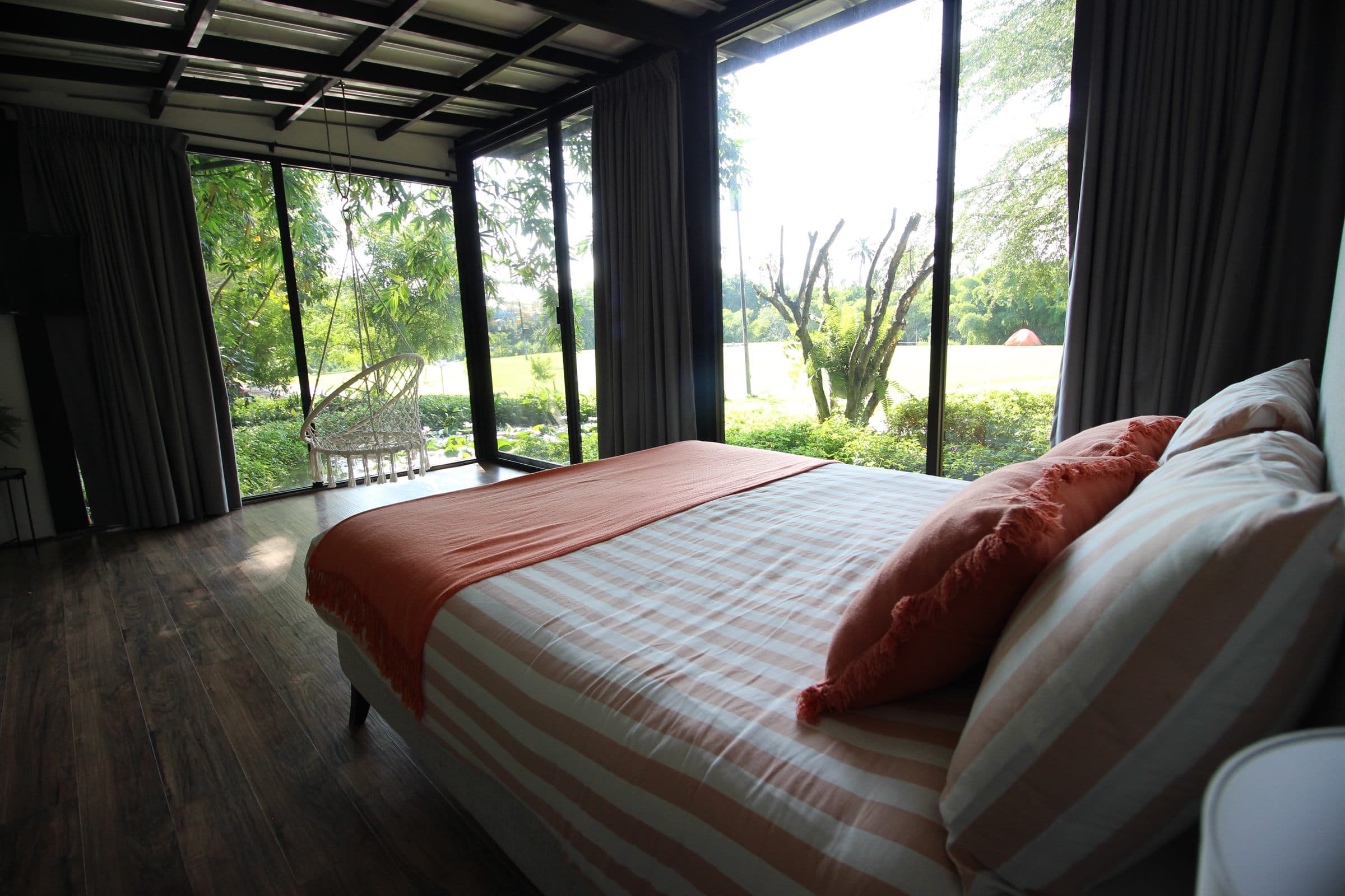 Cama con vista al jardín a través del ventanal esquinero
