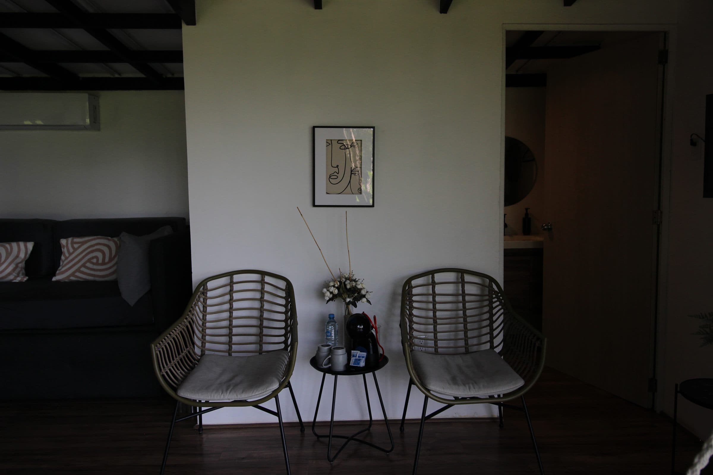Rincón de estar de la habitación con dos sillas de ratán